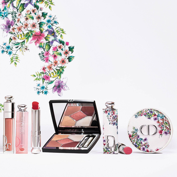 Dior makeup products including lipsticks, a compact, and others with floral design on a white background.