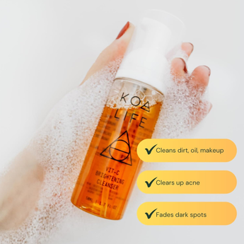 Koa Life cleanser bottle with a hand holding it, surrounded by bubbles on a light background.