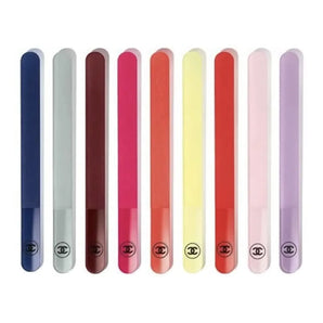 A set of nine Chanel color-coded nail files, displayed in a line, with a range of colors including blue, pink, red, yellow, and purple.
