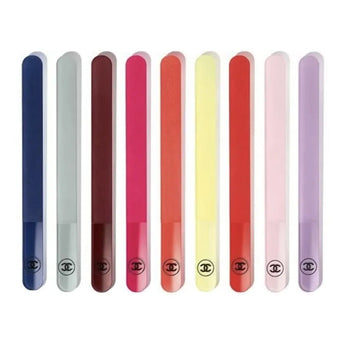 A set of nine Chanel color-coded nail files, displayed in a line, with a range of colors including blue, pink, red, yellow, and purple.
