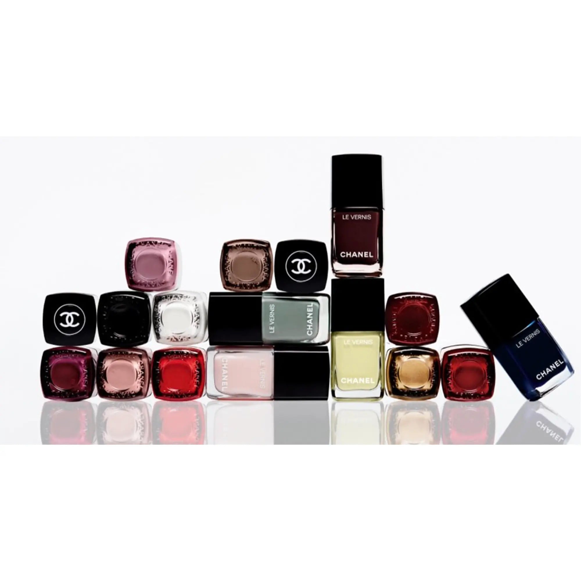 A set of Chanel nail polish bottles in various colors, including shades of red, blue, green, orange, purple, and yellow.