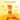 MUDMASKY French Kiss Lip Balm tube centered over sliced oranges on a pale yellow background, with callout text describing benefits: deep daily hydration, lightweight comfort, smooths dry lips, and non-sticky finish.