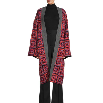 Red and black patterned cardigan over a black outfit on a white background