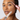 A close-up of a woman applying brow pomade with a pink wand while holding the clear tube labeled 'niabrow' against a light gray background.